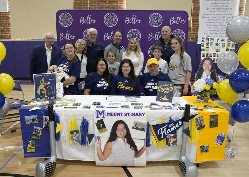 student athlete sitting at table surrounded by family
