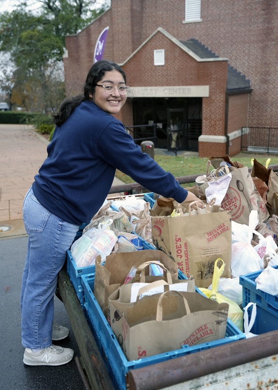 student loading bags of canned goods into trailer
