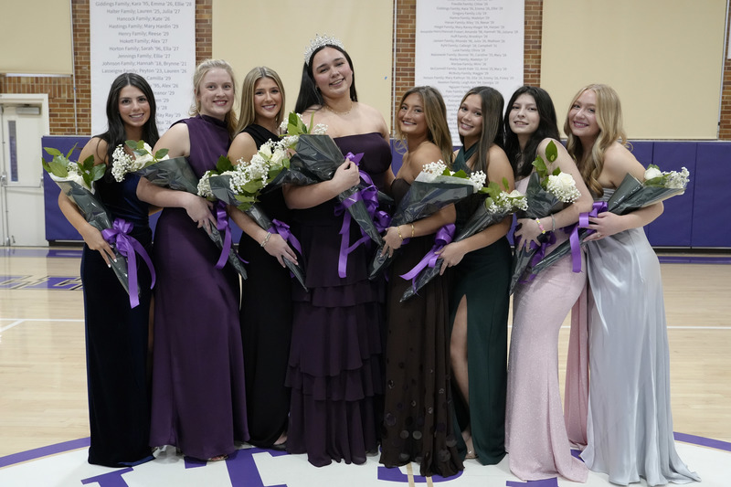 eight young women dressed in formal gowns and holding bouquets of flowers