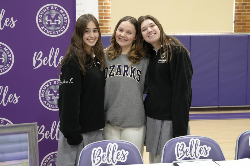 student and two friends pose for photo at decorated table