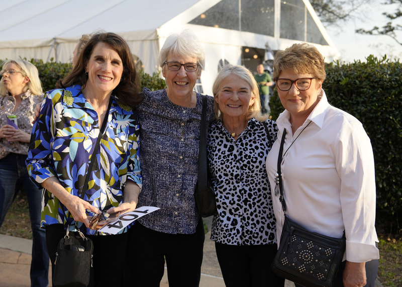 four event guests standing outside and smiling for the camera