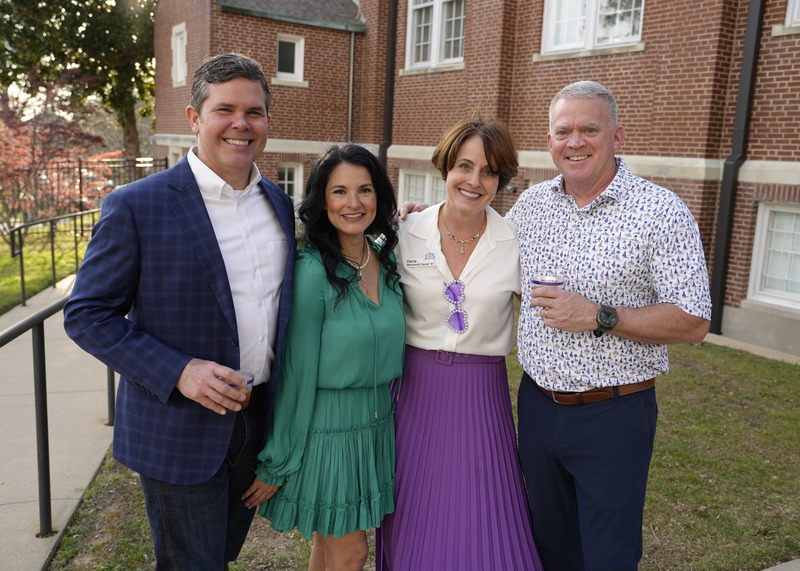 four event guests standing outside and smiling for the camera