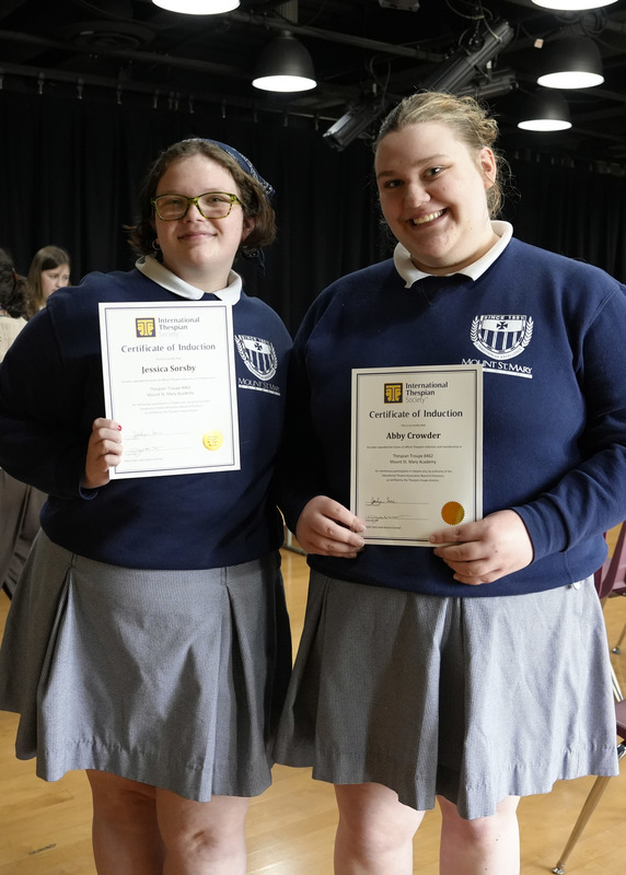 two students holding award certificates
