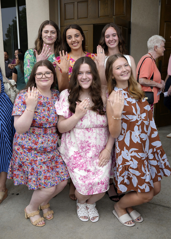 group of six girls smiling at camera and holding up hands to show newly received senior rings
