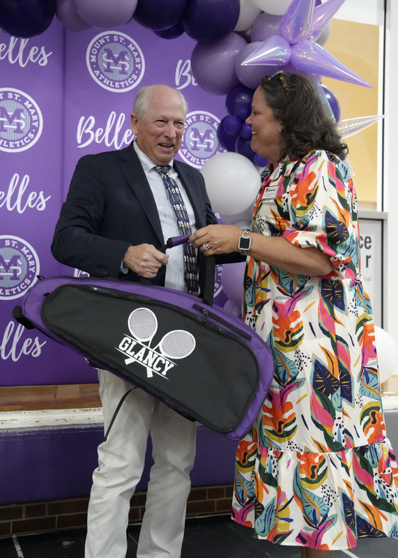 a retiring coach receiving a personalized gift from the athletic director