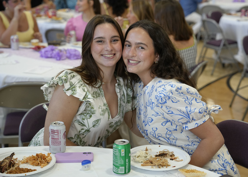 two students seated at a table enjoying a meal during a banquet