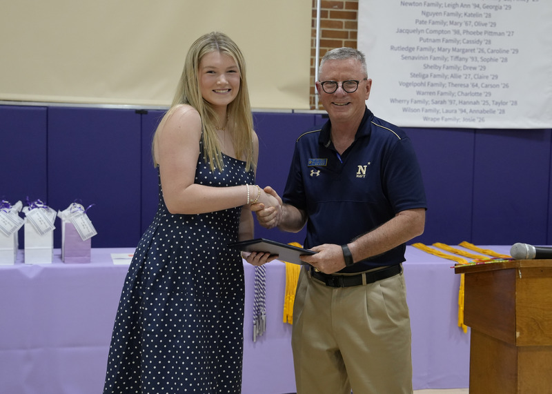 a student accepting an award certificate from a faculty member