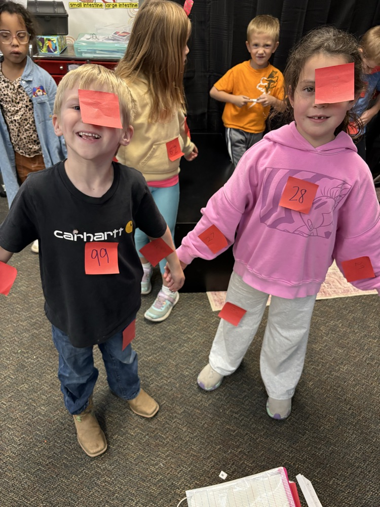boys using post its to find 10 less and 10 more of a number