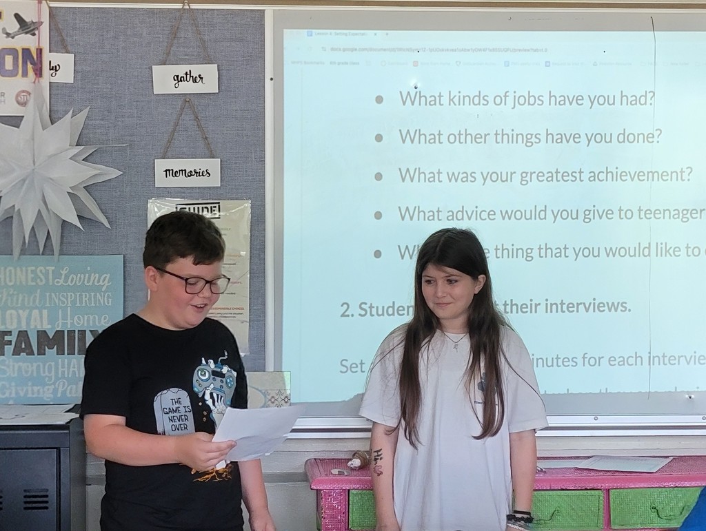 a boy and girl student presenting in front of class