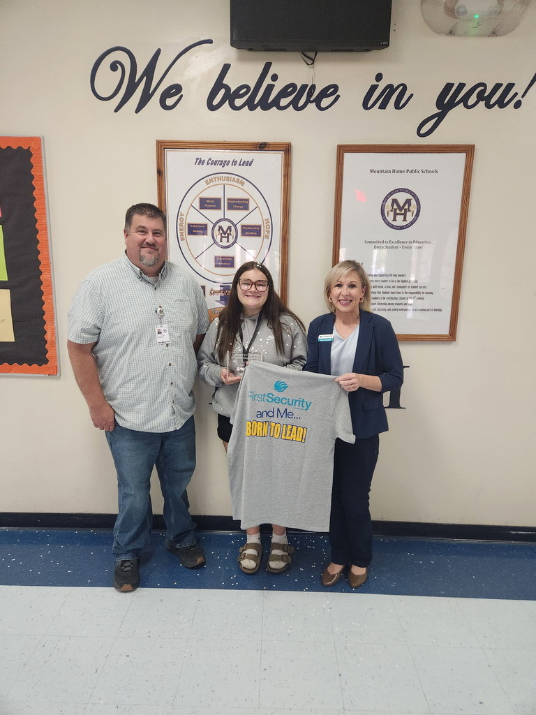 a girl and two adults hodling tshirt