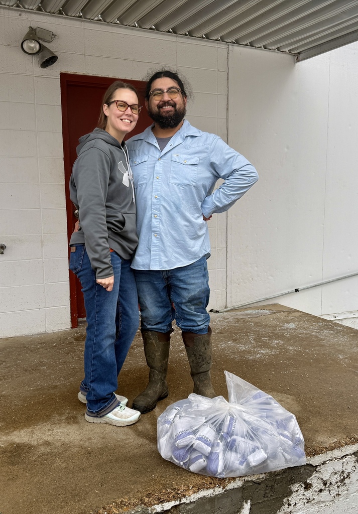 business owners husband and wife posing with sausage