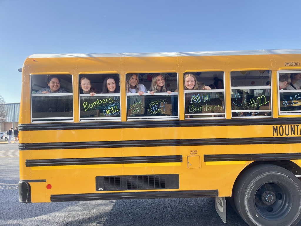 School bus with the girls basketball team looking out of the windows