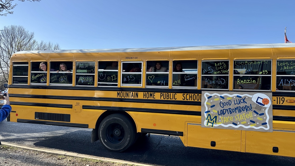 School bus with the girls basketball team looking out of the windows
