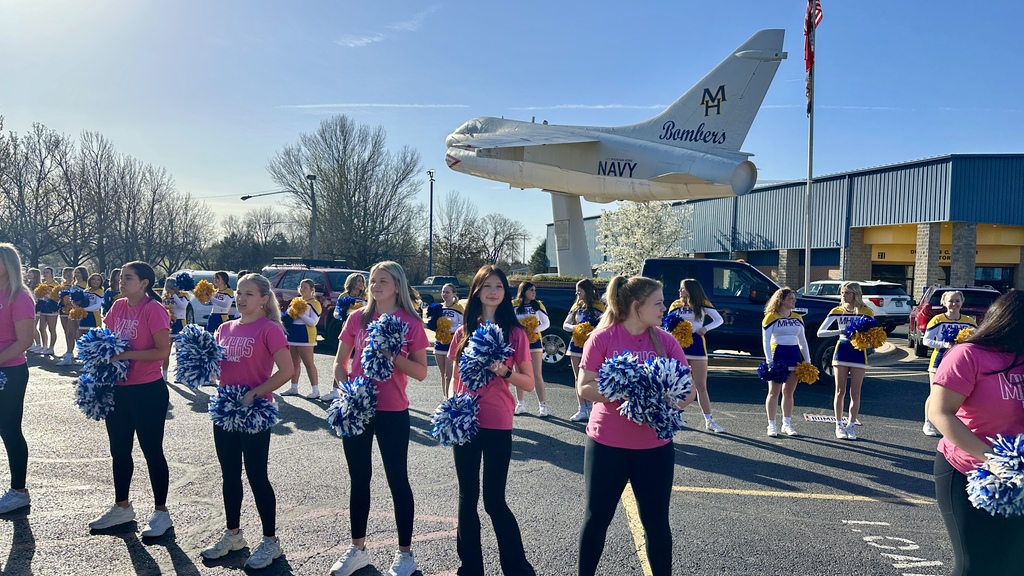 Dance team standing in front of the high school 