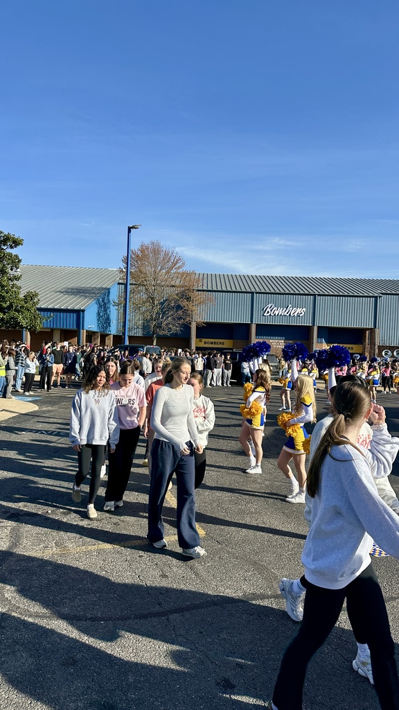Girls basketball team walking through a crowd of students to get onto the bus