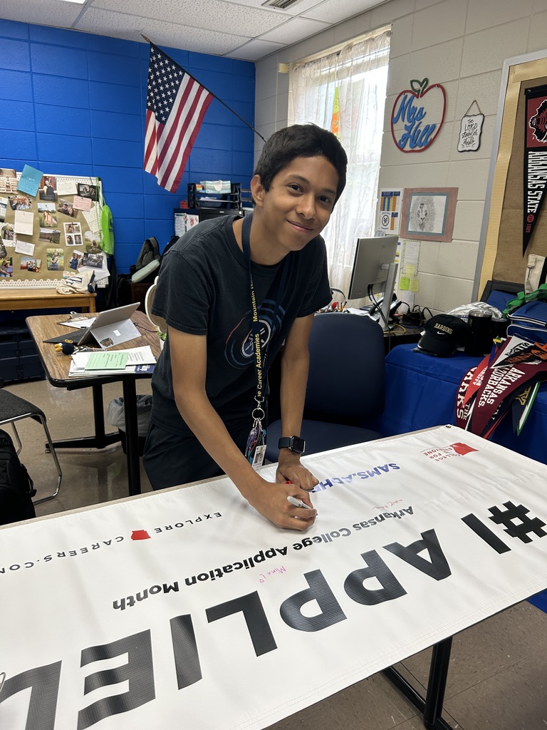 male student signing a banner