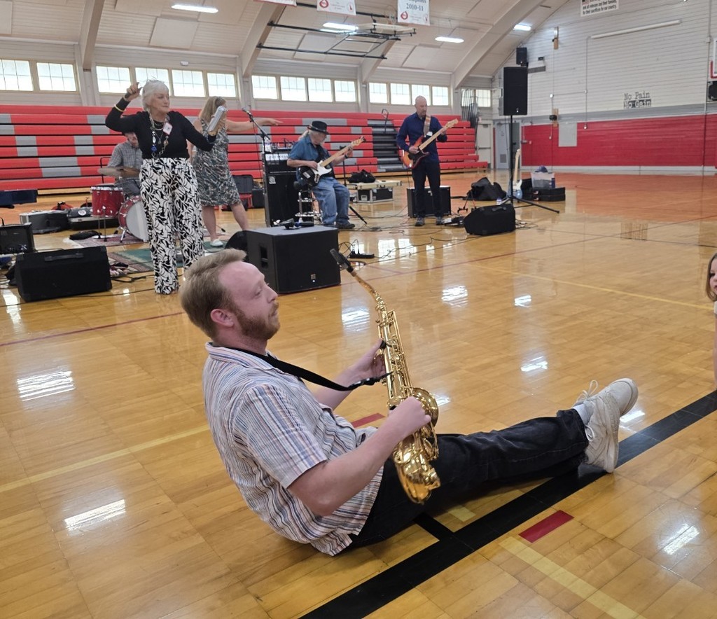 Clarkston Middle School Teacher plays the Saxophone on the ground for students to get up close and personal with music.
