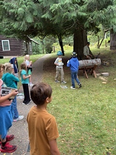  Working together to cut through a log.