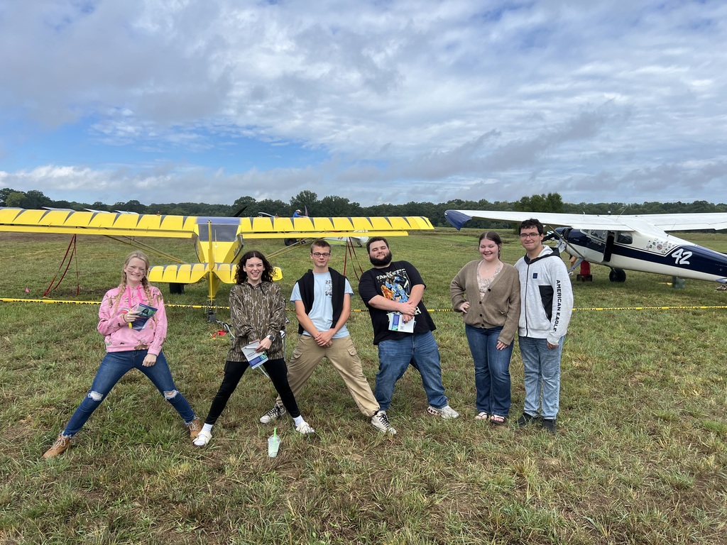 Seniors in front of a plane