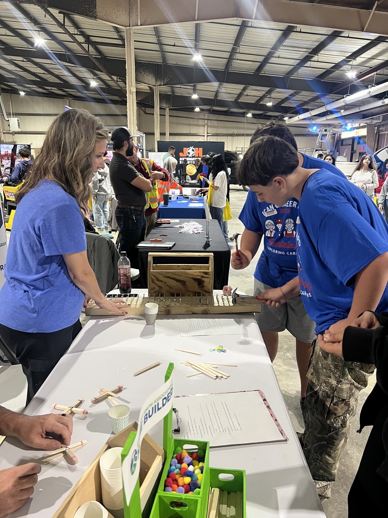 Students learning about the construction career pathway by racing to hammer a nail into a board as fast as possible