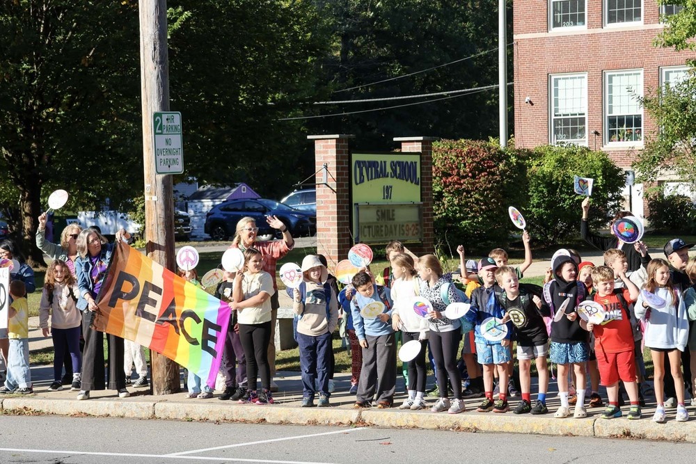 Students from the Central School great motorists as they perform a parade in celebration of the International Day of Peace