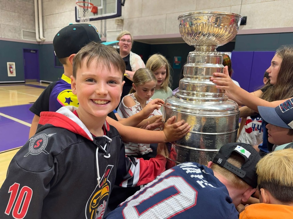 Students from the Great Works School read names from the NHL Stanly Cup Trophy
