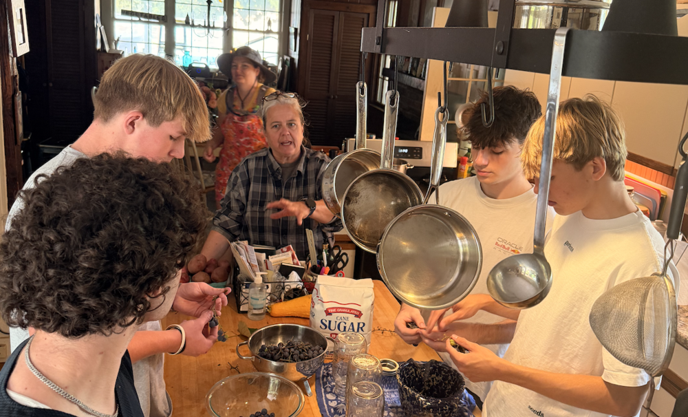 Dawn Lalos teaches students how to make juice from grapes they just picked on a farm trip
