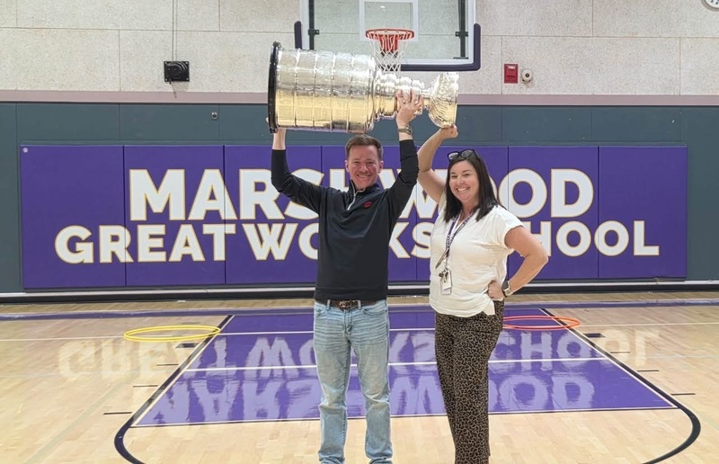 The NHL Stanley Cup trophy being held in the Great Works school gym