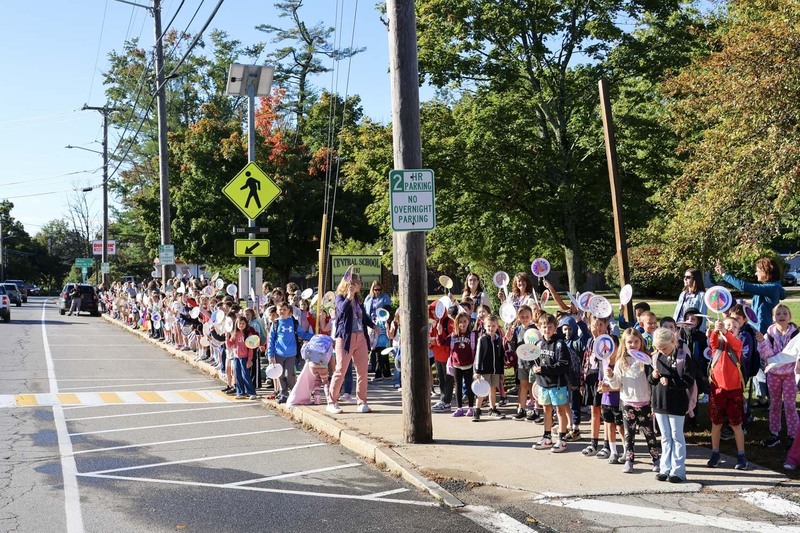 Sudents from the Central School gather on the sidewalk outside the school to celebrate  the International Day of Peace with passing residents, holding handmade signs.