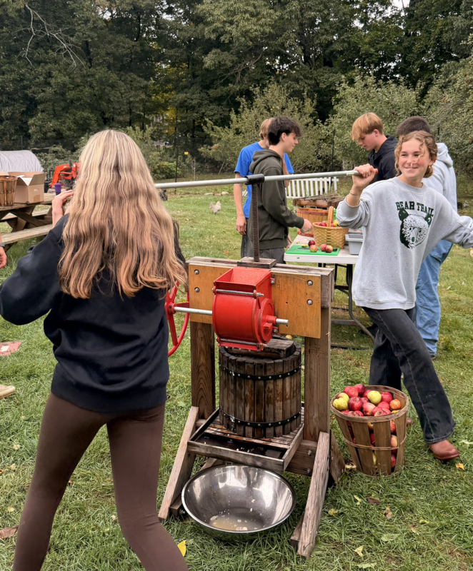 Students from Newmarket High School learn to press apples