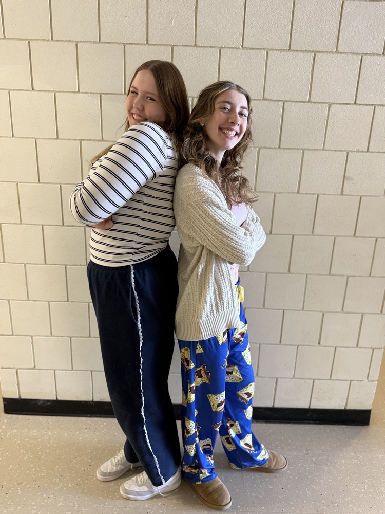 students posing back to back in school hallway