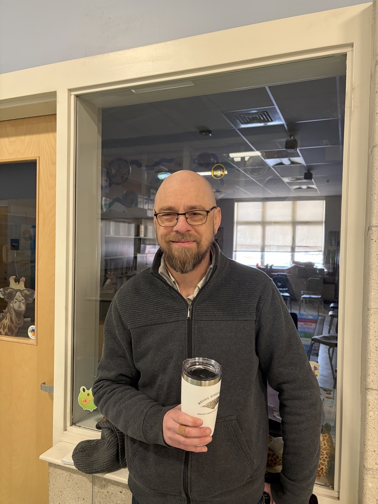 teacher in hallway holding cup