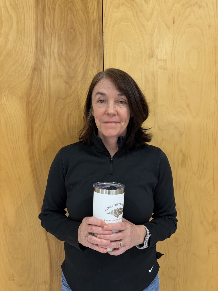 teacher holding cup in school gym