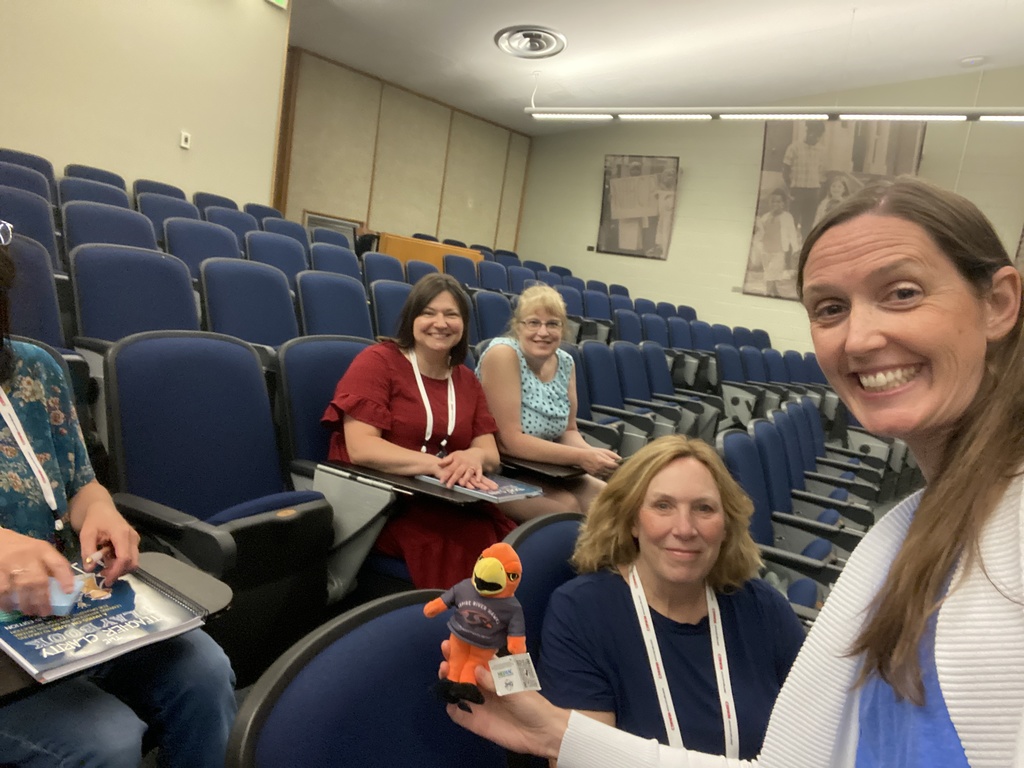 Teachers inside classroom with River Hawk plushie