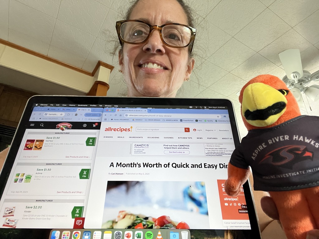 Teacher with River Hawk plushie clipping coupons and researching recipes