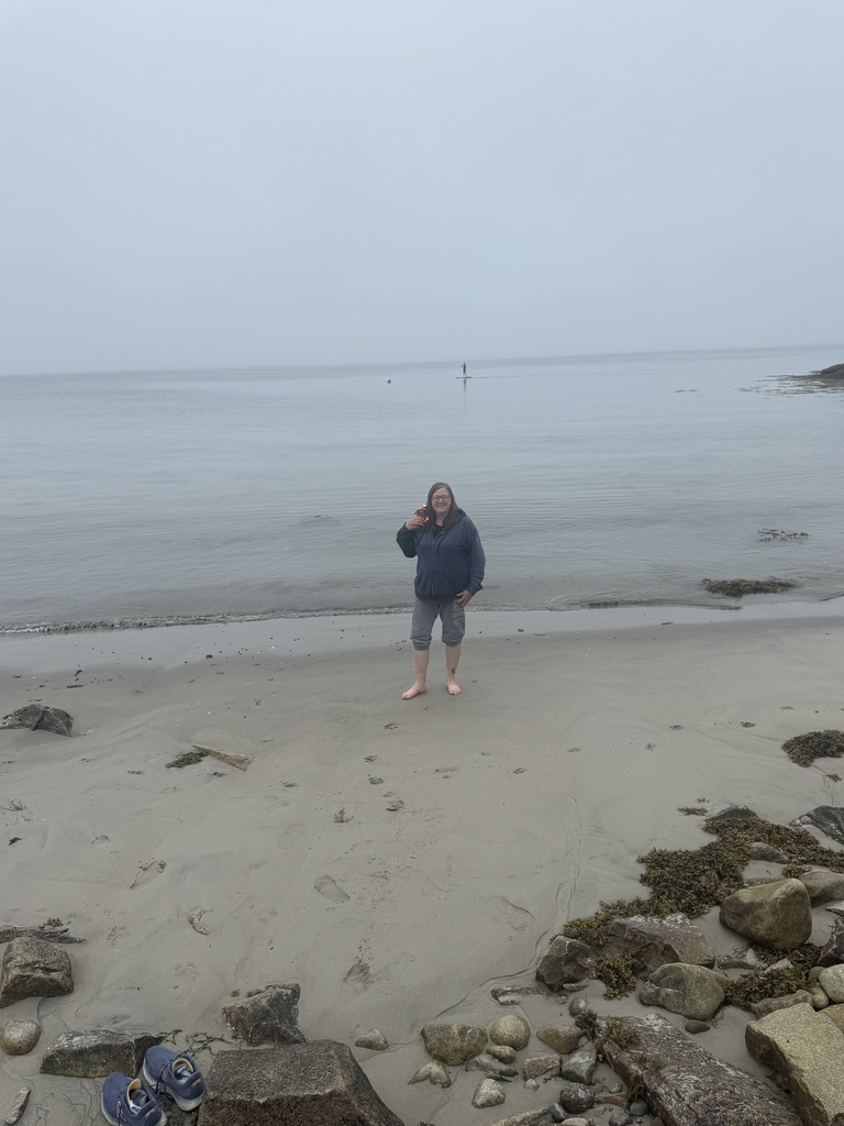 teacher with river hawk plushie on the beach