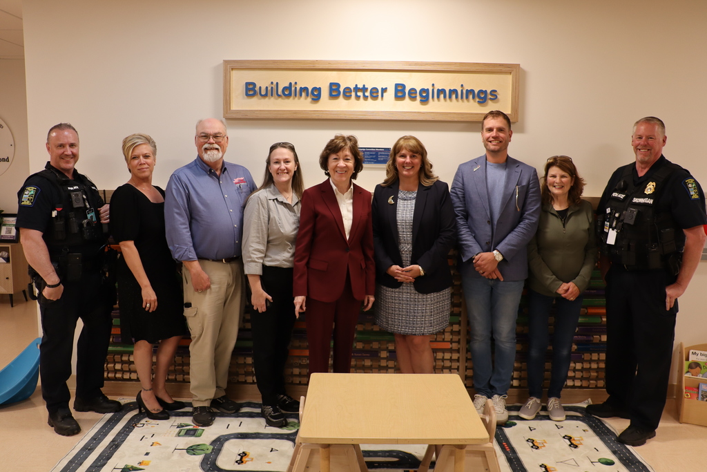 Senator with school and community representatives in  school, in front of Building Better Beginnings sign