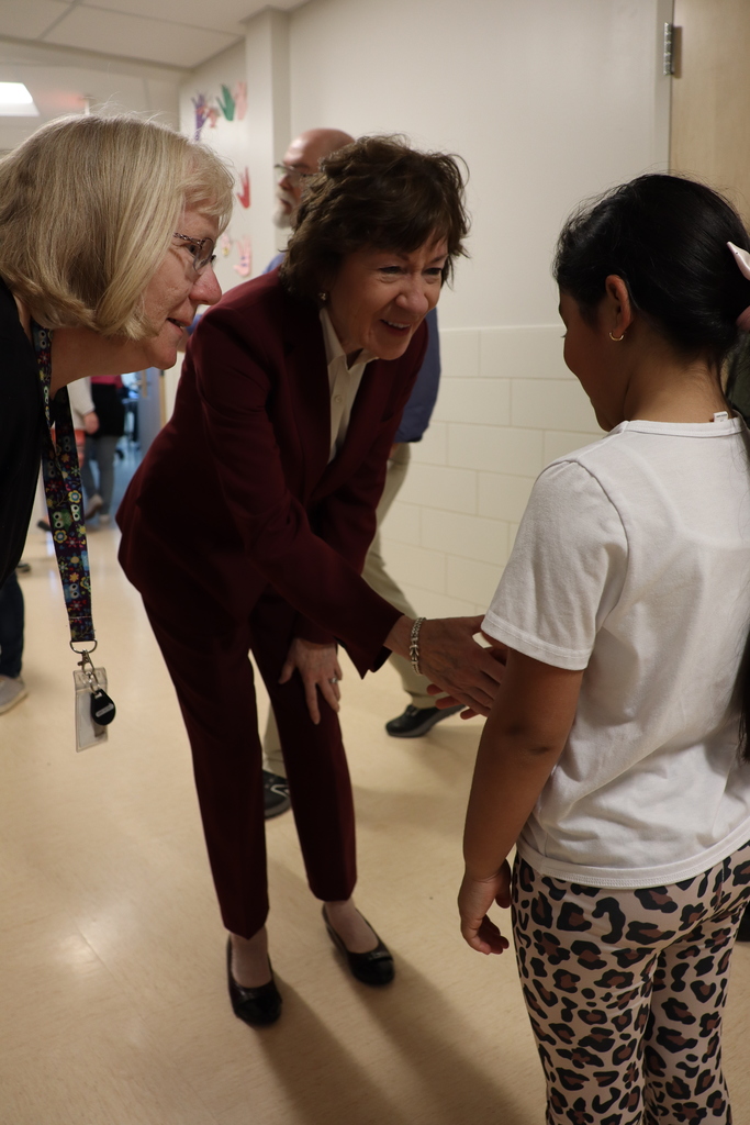 Senator and Teacher greeting student in school hallway