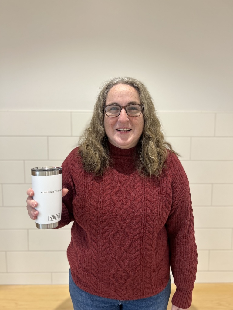Staff member holding cup in school lobby