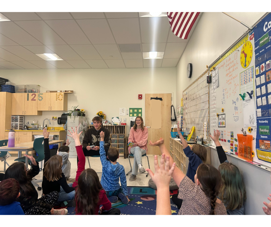 students raising hands in classroom