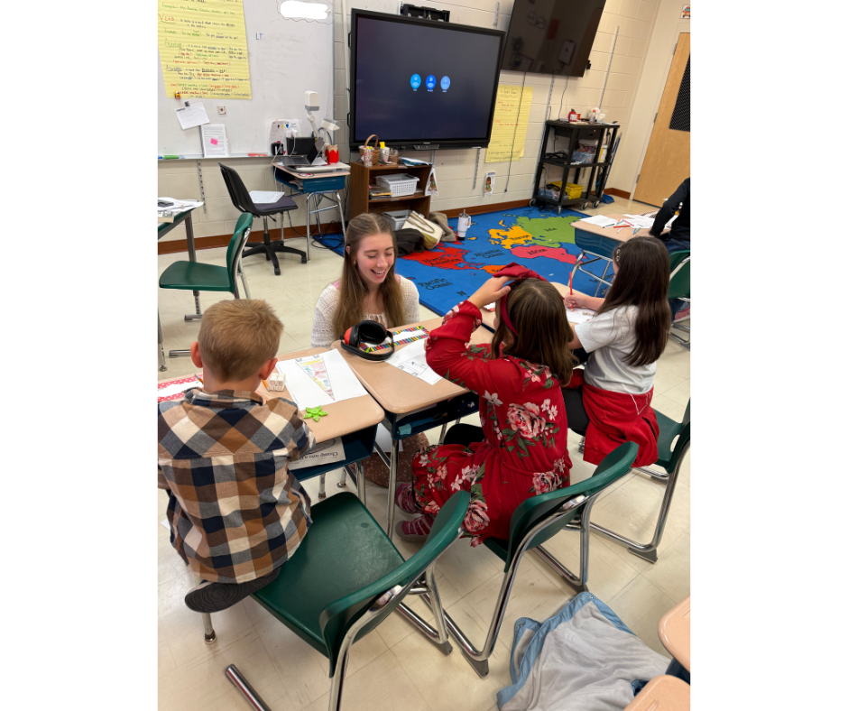 students talking at desks in classroom