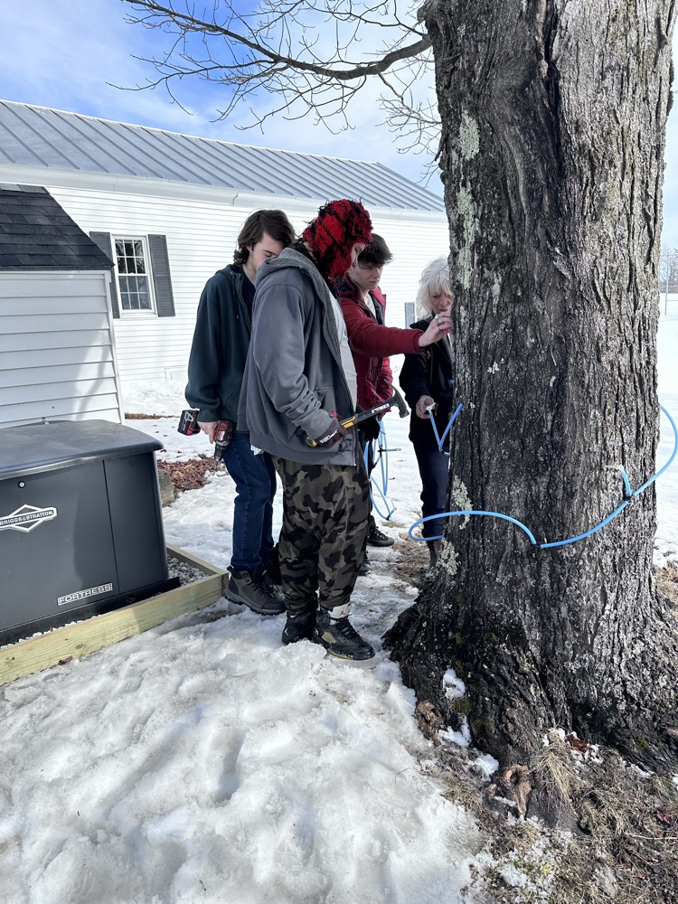3 students and one staff placing a set of taps