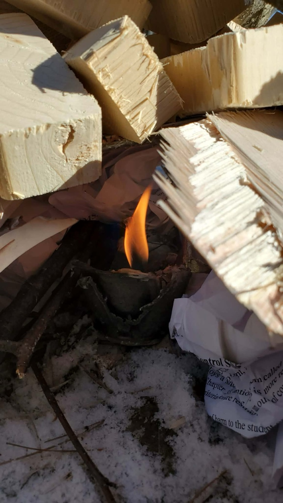 home made fire starter under a couple logs