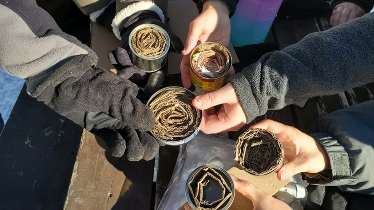 5 students hands holding the fire starter they made