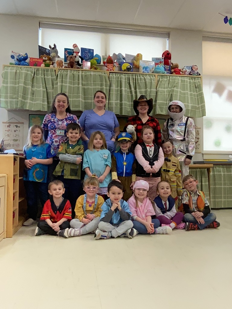 A classroom of students lined up for a photograph dressed in costumes.