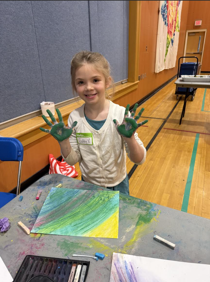 A girl holds up her painted hands.