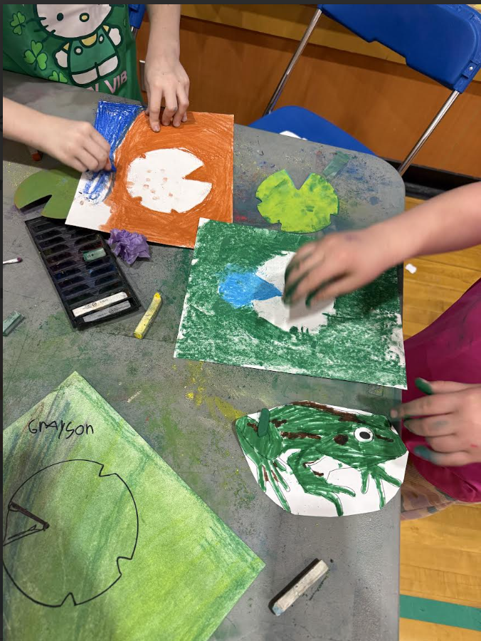 A table of art work being created to look like lily pads.
