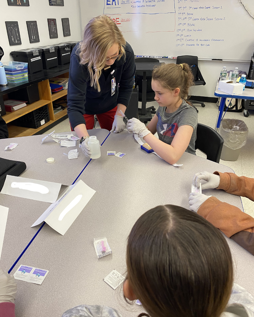 Students working with medical equipment with an adult.