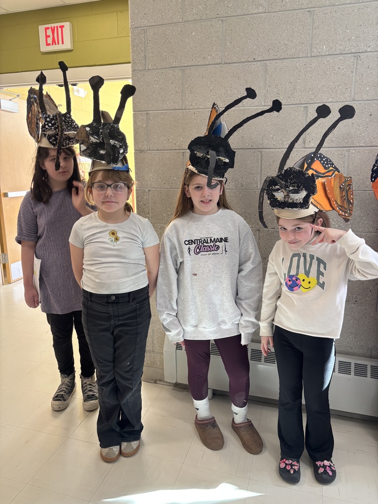 Students wear monarch butterfly headdresses. 