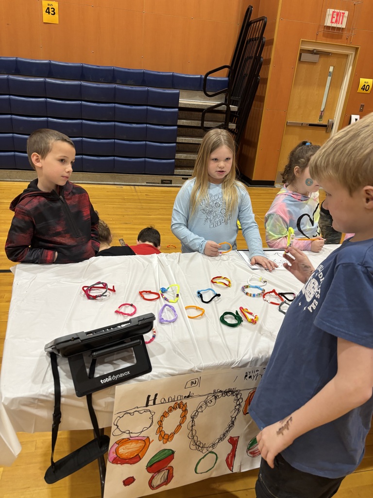 A boy and a girl stand at a table.